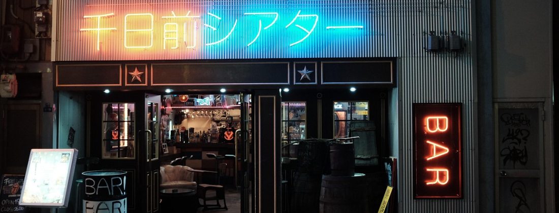 日本东京街头夜景，霓虹灯招牌上的japanese文字清晰可见，行人在繁华商业街穿梭，展示japanese语言在真实生活场景中的存在感