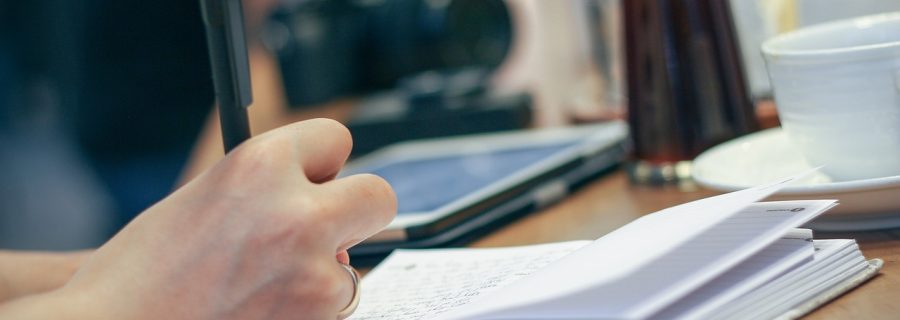 japanese语法学习笔记本特写，页面上整齐写着助词用法对比和动词活用变化表，旁边有彩色荧光笔标注重点